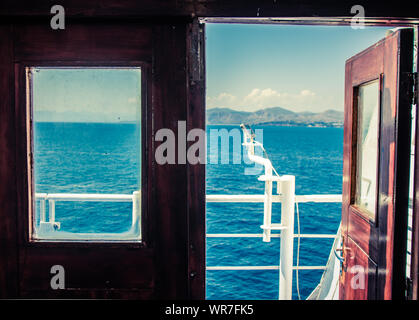 Blick auf das Meer von rot vintage Tür auf eine Fähre. Stockfoto