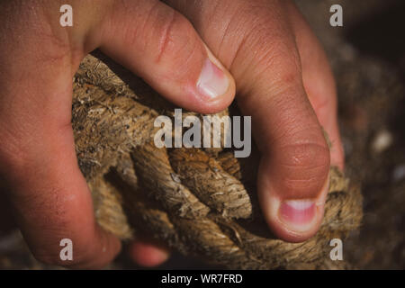 Eine Nahaufnahme Bild eines mans Hand getragen alte Seil Stockfoto