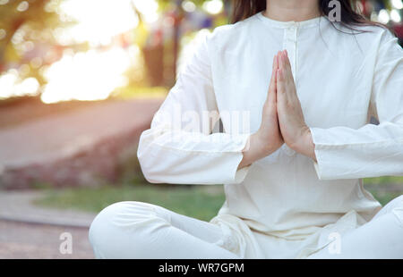 Nahaufnahme von Frau Hände in Namaste. Meditation auf dem Hintergrund der Tempel und der Natur. Yoga Klassen in einem Retreat Center. Stockfoto