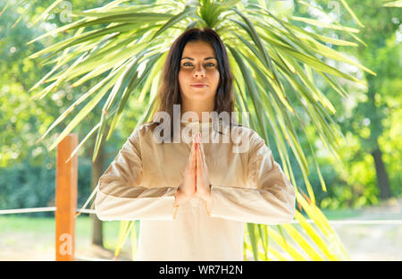 Brünette Frau meditiert auf Natur Hintergrund. Yoga Übungen auf dem Rückzug. Stockfoto