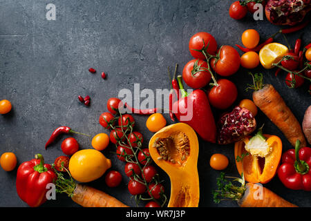 Flatlay mit buntem Gemüse und Kopieren. Kürbis in Scheiben, Tomaten, Paprika, Karotten und Zitronen von oben betrachtet. Gesund Stockfoto