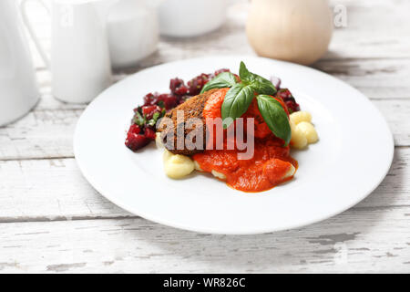 Kürbis Koteletts serviert mit Tomatensauce auf Knödel auf Gnocchi, geröstete Rüben Salat. Stockfoto