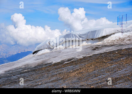 Marmolada Gletscher, Italien - 28. August 2019: verdichtetem Schnee geschützt mit weißen Laken gegen Schmelzen, unter der Sommersonne in Punta Rocca, Marmolada Stockfoto