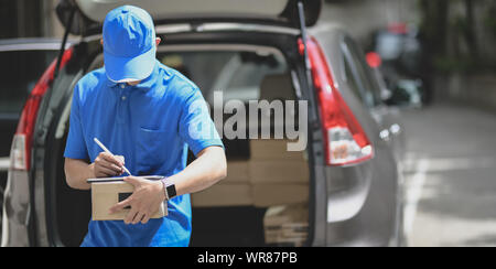 Professionelle Delivery Man arbeiten mit Paketboxen, Kundenauftrag im Auto Stockfoto