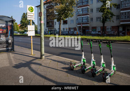 Kalk e-Scooter an einer Bushaltestelle im Bereich Berlin Neukölln geparkt, Deutschland Stockfoto