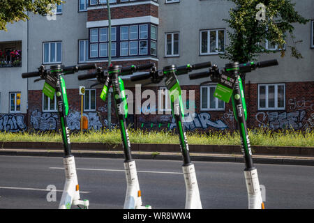 Kalk e-Scooter an einer Bushaltestelle im Bereich Berlin Neukölln geparkt, Deutschland Stockfoto