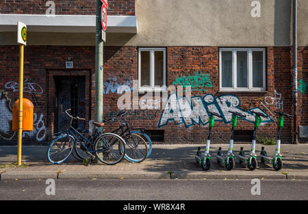 Kalk e-Scooter an einer Bushaltestelle im Bereich Berlin Neukölln geparkt, Deutschland Stockfoto