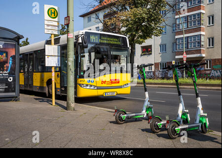 Kalk e-Scooter an einer Bushaltestelle im Bereich Berlin Neukölln geparkt, Deutschland Stockfoto