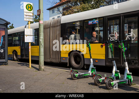Kalk e-Scooter an einer Bushaltestelle im Bereich Berlin Neukölln geparkt, Deutschland Stockfoto