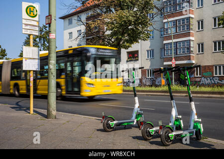 Kalk e-Scooter an einer Bushaltestelle im Bereich Berlin Neukölln geparkt, Deutschland Stockfoto