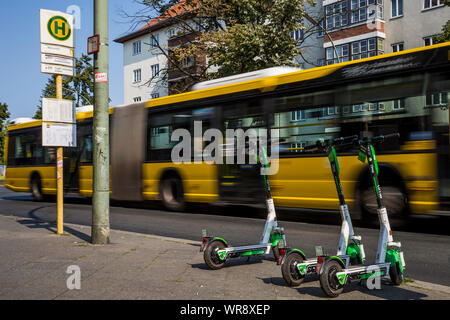 Kalk e-Scooter an einer Bushaltestelle im Bereich Berlin Neukölln geparkt, Deutschland Stockfoto