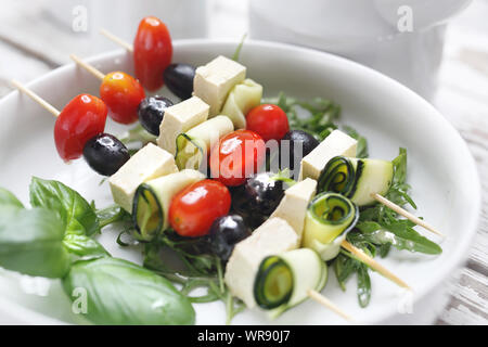 Pflanzliche Schaschlik aus Cocktailtomaten, Mozzarella und schwarzen Oliven. Stockfoto