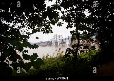 Blick von Long Bien Brücke durch Blätter, Hanoi, Vietnam. Stockfoto