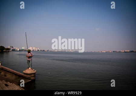 Ein Fischer am Rande des West Lake in Hanoi, Vietnam. Stockfoto