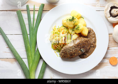 Abendessen serviert. Schnitzel mit Kartoffeln und Weißkohl Salat Stockfoto