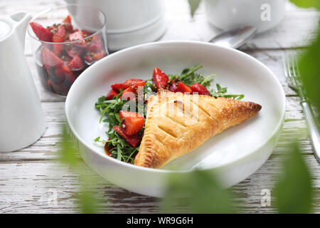 Ein ricotta puff Kegel mit Rucola Salat und Erdbeeren in Aceto Balsamico serviert mit grünem Pfeffer. Stockfoto