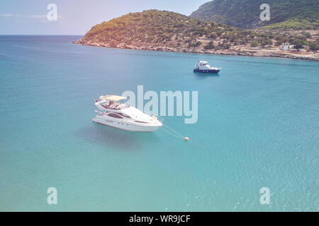 Zwei Yachten in der gemütlichen tropischen Meer Lagune auf den Vordergrund im sonnigen Sommertag. Luftaufnahme von UAV-Drohne Stockfoto