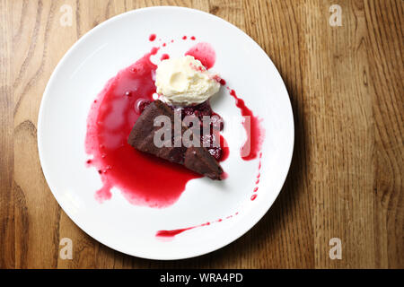 Chocolate Brownie mit Himbeersauce und Eis. Stockfoto