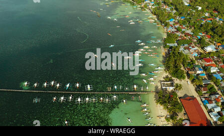 Stadt Allgemeine Luna an der Küste von Siargao mit einem Pier, ein Hafen und touristische Boote bei Sonnenaufgang, Luftbild. Sommer und Reisen Urlaub Konzept. Stockfoto