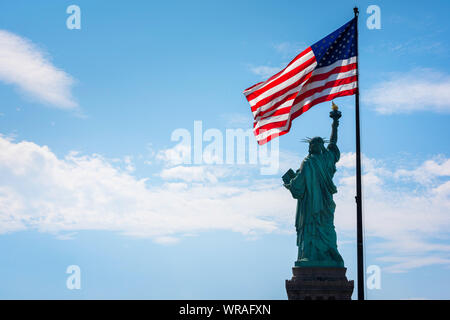 Freiheitsstatue USA, Ansicht von der Rückseite der Freiheitsstatue und einer beleuchteten Sternenbanner Flagge, Liberty Island, New York City, USA Stockfoto