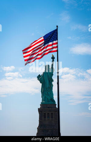 Freiheitsstatue USA, Ansicht von der Rückseite der Freiheitsstatue und einer beleuchteten Sternenbanner Flagge, Liberty Island, New York City, USA Stockfoto