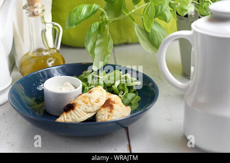 Gebackene Teigtaschen mit Gemüse gefüllt serviert mit Joghurt Sauce. Stockfoto