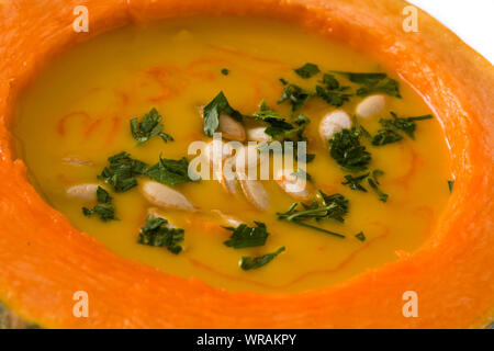 Kürbis und Karotten Suppe auf Holztisch. Herbst essen. Nahaufnahme Stockfoto