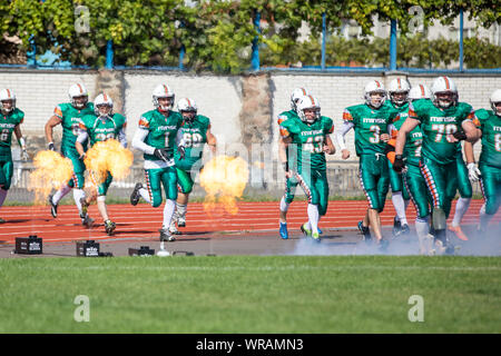 Start des American Football Spiel. Show mit Feuer. Mannschaften in das Stadion. amerikanischen Fußball-Wettbewerbe Hengste Kiew - Hurrikane Minsk 08.0 Stockfoto