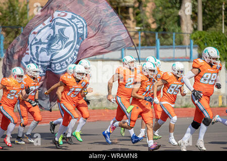 Start des American Football Spiel. Show mit Feuer. Mannschaften in das Stadion. amerikanischen Fußball-Wettbewerbe Hengste Kiew - Hurrikane Minsk 08.0 Stockfoto