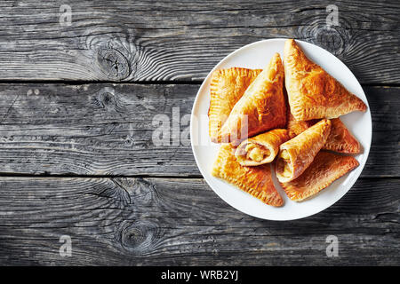 Frisch gebackenen Blätterteig apple Umsatz an weiße Platte auf einem alten Holztisch, horizontale Ansicht von oben, flatlay, Nahaufnahme, leeren Raum Stockfoto