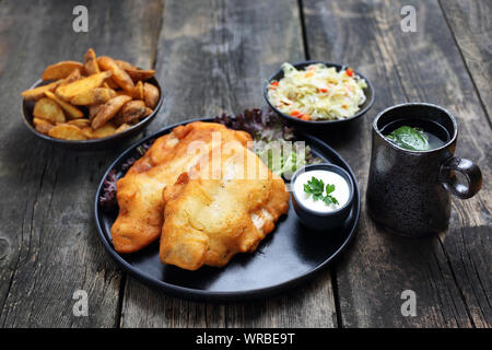 Gebratener Fisch in Teig mit Pommes und Salat. Stockfoto