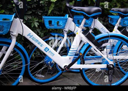 Alipay-unterstützten gemeinsamen Fahrräder Bike-sharing service Hellobike entlang der Straße in der Stadt Guangzhou, Provinz Guangdong im Süden Chinas gesäumt, Stockfoto