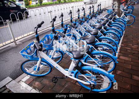 Alipay-unterstützten gemeinsamen Fahrräder Bike-sharing service Hellobike entlang der Straße in der Stadt Guangzhou, Provinz Guangdong im Süden Chinas gesäumt, Stockfoto