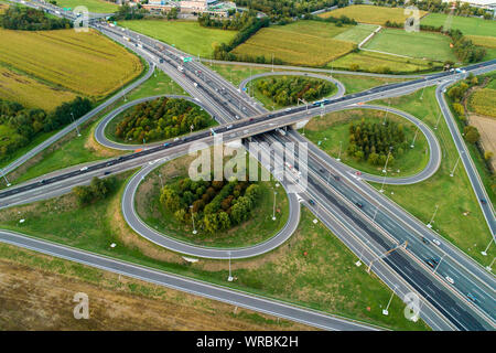 Kleeblatt interchange von oben gesehen. Luftaufnahme von Highway Kreuzung in die Landschaft. Bird's Eye View. Stockfoto