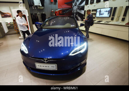 ** Datei ** Menschen sehen ein Tesla Model S Elektro-auto zu einem Tesla store in Hangzhou City, East China Zhejiang Provinz am 4. April 2018. Uns elektrischen c Stockfoto