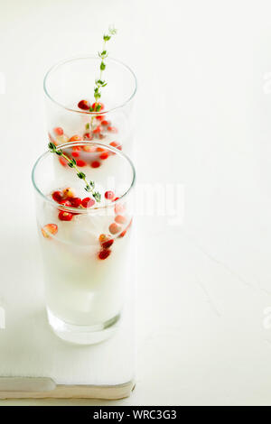 Weihnachten und Thanksgiving vegan Cocktail white coconut Margarita oder Durchschlag mit Preiselbeeren und Zweig Thymian auf weißem Hintergrund mit Kopie Raum Stockfoto