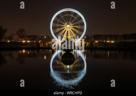 PARIS, Frankreich, 3. DEZEMBER 2013: Beleuchtete Standlupe Riesenrad bei Nacht auf dem Place de la Concorde, auf einem Becken in den Tuilerien Garten widerspiegelt. Stockfoto