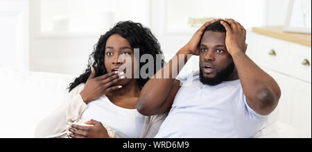 Emotionale schwarz Paar Horror Film auf dem Fernseher ansehen Stockfoto