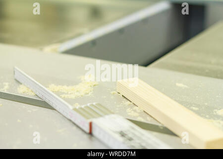 Klappbare Maßstab auf dem Maschinentisch mit Werkstück und Sägemehl, Späne, arbeiten in handwerklichen, Werkstatt, Schreinerei Zimmerei Stockfoto