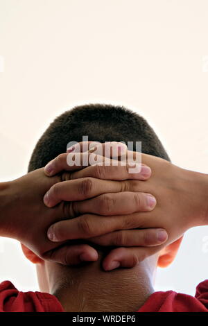 Nahaufnahme der Hände hinter am Hals Stockfoto