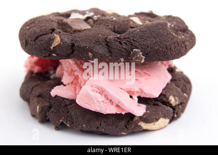 Zwei Schokolade Cookies mit Cherry ice cream sandwiched zwischen Ihnen, auf weißem Hintergrund Stockfoto