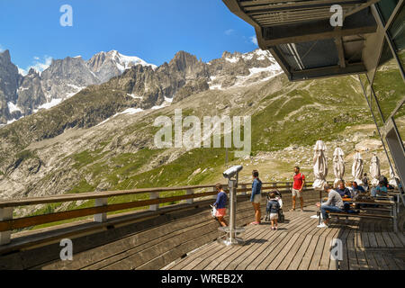 Blick auf das Mont Blanc Massiv von der Terrasse Restaurant von Pavillon Seilbahnstation der Skyway Monte Bianco mit Wanderern, Courmayeur, Italien Stockfoto