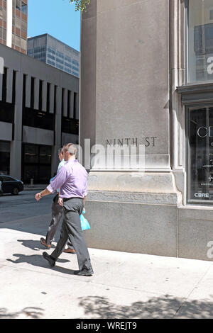 Zwei Geschäftsleute entlang der Ninth Street in der Innenstadt von Cleveland, Ohio, USA, an einem späten Sommernachmittag. Stockfoto