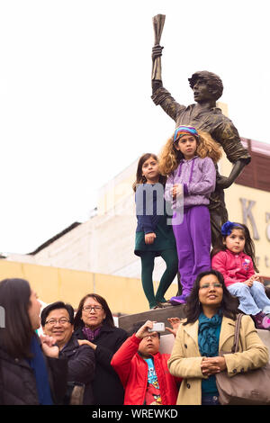 LIMA, PERU - 21. JULI 2013: Unbekannter Leute beobachten die Parade der Wong von der Statue des "Lector" auf der Avenue Ricardo Palma Stockfoto