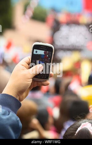 LIMA, PERU - 21. JULI 2013: Nicht identifizierte Person, die einen Blackberry Handy ein Foto auf der Wong Parade in Miraflores zu nehmen, am 21. Juli 2013 Stockfoto