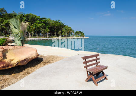 Holzbank, wunderschönen Blick auf die ruhige See. Grüne Umgebung Landschaft, entspannender Ort mit einer Bank auf einem Ufer von Pattaya, Thailand Stockfoto