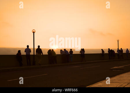 LIMA, PERU - 11. MÄRZ 2012: Unbekannter Menschen beobachten Sie den Sonnenuntergang über dem Pazifischen Ozean von den Bürgersteig entlang des Malecon De La Reserva Stockfoto