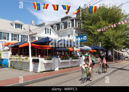 Fahrradfahrer pass Terrasse American Grill Restaurant auf Commercial Street in Provincetown, Massachusetts. Stockfoto