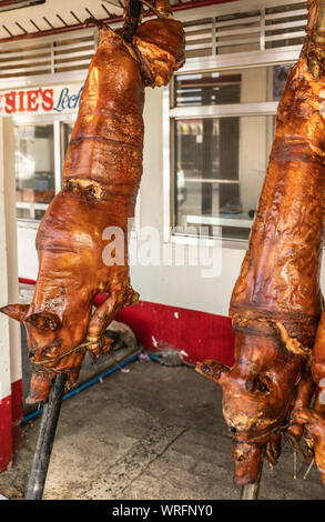 Manila, Philippinen - 5. März 2019: Calavite Straße in Salvacion Teil der Stadt. Zwei ganze Schweine gebraten auf Spits, genannt Lechon Baboy, angezeigt mit p Stockfoto