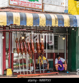 Manila, Philippinen - 5. März 2019: Calavite Straße in Salvacion Teil der Stadt. Sieben Ferkel gebraten auf Spits, genannt Lechon Baboy, angezeigt w Stockfoto